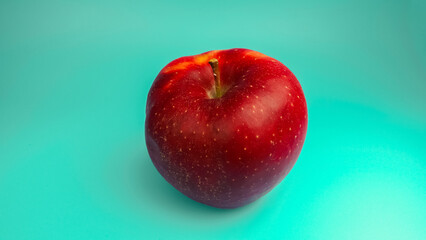Red apple on a turquoise background.