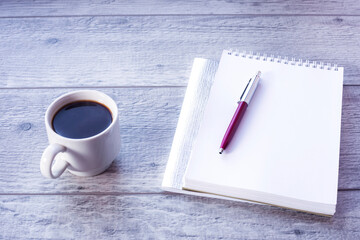 Open notebook with pen and coffee in studio