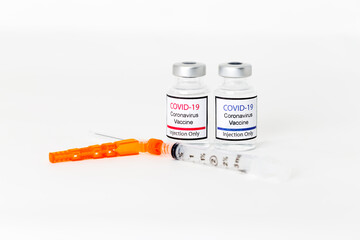 Covid-19 vaccine and syringe on white background.