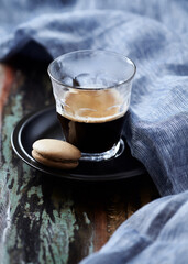 Coffee in glass cup on rustic wooden background. Close up.