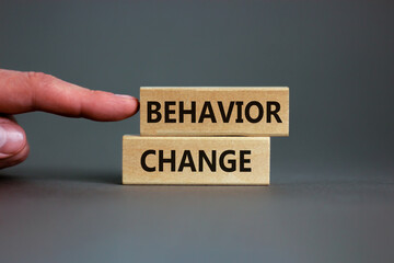 Time to behavior change symbol. Wooden blocks with words 'behavior change'. Beautiful grey background. Businessman hand. Copy space. Business, psychology and behavior change concept.