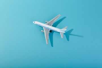 Fototapeta na wymiar toy airplane on blue background top view with space for text