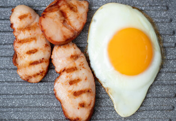 Cooking chicken fillet in a grill pan at home. fried egg. Breakfast for one. Grill fresh chicken breast. Fry the chicken in a grill pan. Chicken egg cooked in a pan. High quality photo