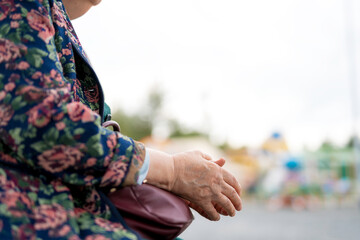 hands of an elderly old woman on a summer day, on the street