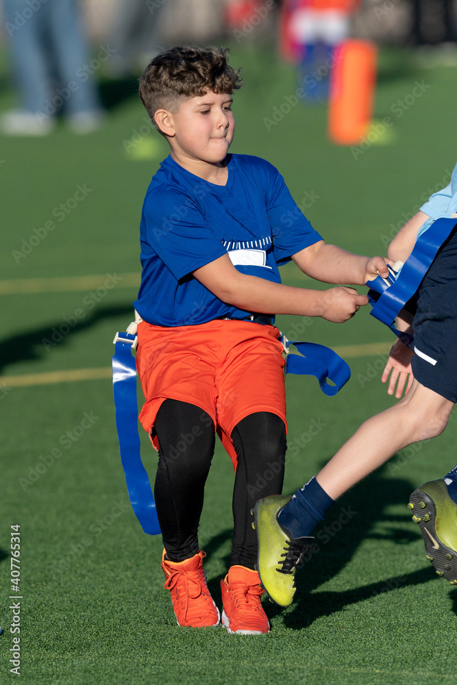 Wall mural Young boy playing flag football