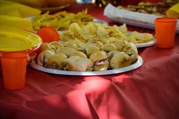 Tavolo imbandito con panini e patatine in primo piano