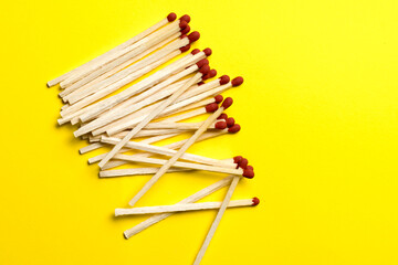 matches are piled on a yellow background close-up.