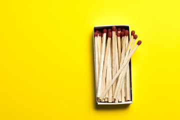 box with matches lies on a yellow background. space for text