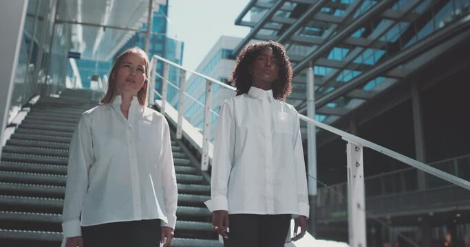 A ethiopian and caucasian young women standing outside a building