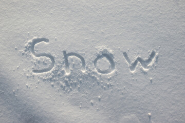 Lettering on the snow in winter. Text on a snowy surface, flat lay.
