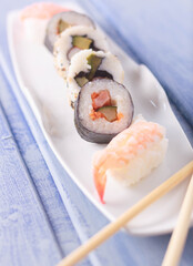 Plato de sushi con palillos para comer.