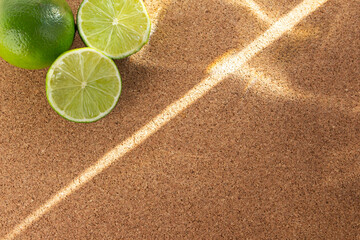Top view of sliced lime on cork  board with space. Sun beams on them.