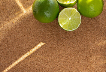Top view of sliced lime on cork  board with space. Sun beams on them.