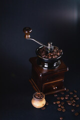 Coffee grinder with coffee beans on black background
