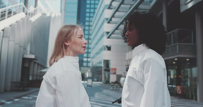 A ethiopian and caucasian young women talking outside a building