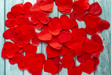 A lot of red small paper hearts on the blue-green wooden backdrop. Valentines day concept