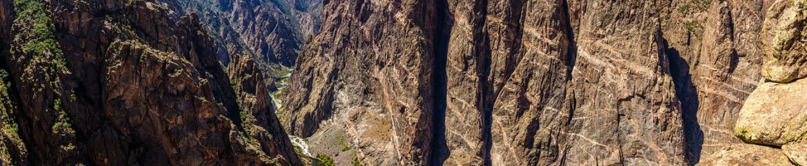 Panorama shot of gunnison river and rocky painted wall in black canyon of gunnison at sunny day in america