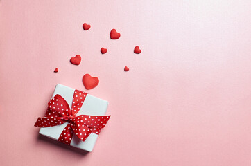 Valentines day gift box with red hearts on pink background
