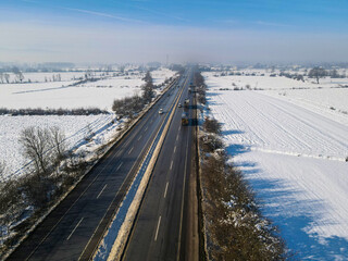 cars driving down the snowy highway