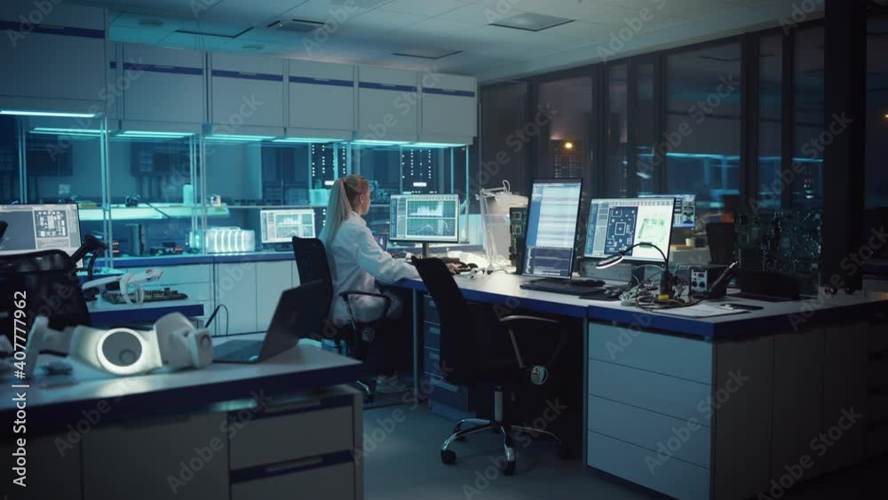 Wall mural modern electronics development facility: female engineer works on computer with robotics programming