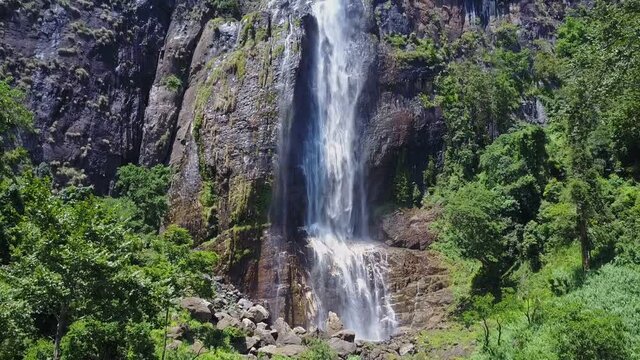 Fantastic Diyaluma falls jets on steep rocky cliff in green wild jungle on sunny day bird eye view. Tropical vacation concept