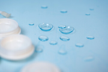 contact lenses on blue background with water drops