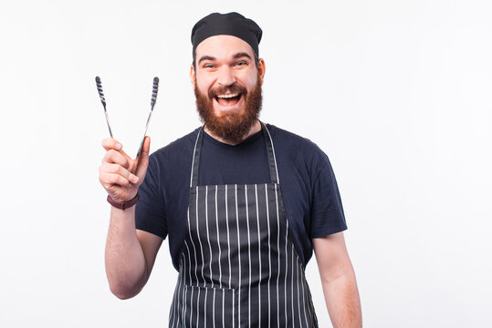 Photo of happy chef man holding utensil for cooking meat.