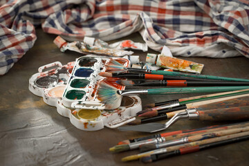 Brushes and paints for painting on an old background.