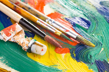 Fototapeta premium Multi-colored oil paints squeezed out of a tube onto a white sheet of paper.