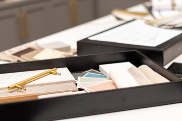 Interior designer's working table, an architectural plan of the house, a color palette, furniture...