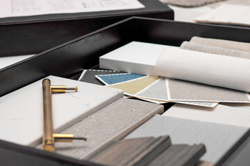 Interior designer's working table, an architectural plan of the house, a color palette, furniture and fabric samples. Drawings and plans for house decoration.