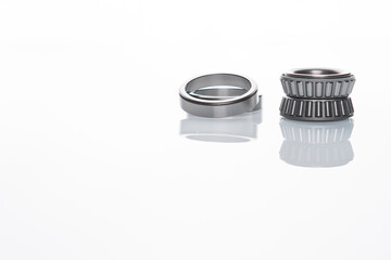 Car bearings, auto part, steel automotive bearings placed on white reflective surface on white...