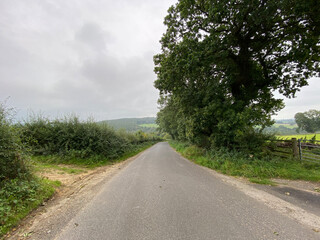 Rain and mist in the distance on, Cinder Lane, with fields, hedgerow, and distant hills in, Farnley, Otley, UK