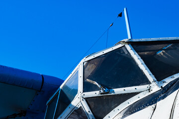 White capit piston plane, engine and propeller on blue sky background.