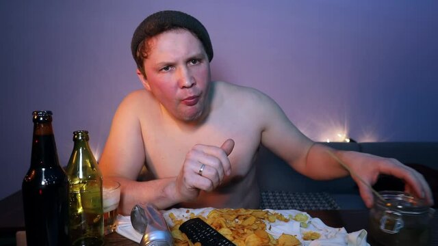 Drunkard eats a cucumber with beer and pours a tin bottle of beer