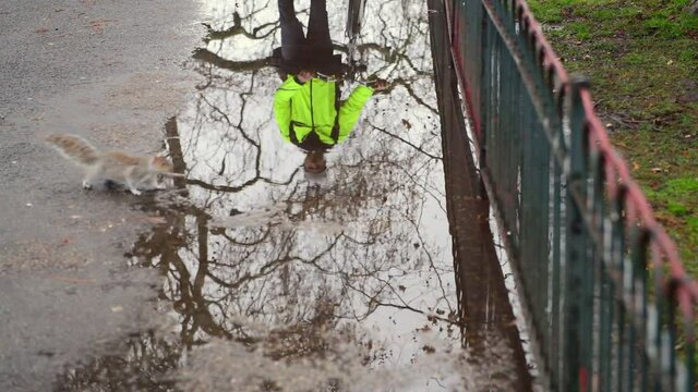 Man with bicycle reflected in puddle, London, UK