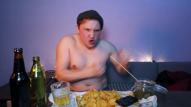 Redneck watches fights without rules and boxes in front of the TV and dances