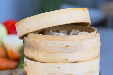Closeup shot of a bamboo steamer with freshly made dumplings