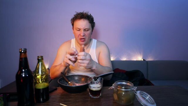 A man from the village watches TV, drinks alcohol and dances