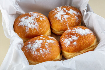 Fresh baked and garnished with powdered sugar german doughnuts - Berliner or Krapfen - on white...