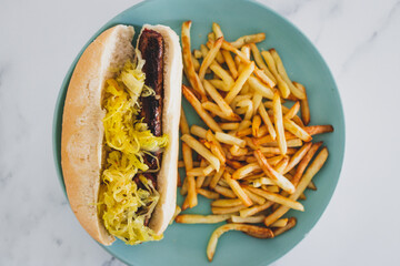 plant-based food, vegan hot dog with sauerkraut and plant-based sausage served with a side of chips