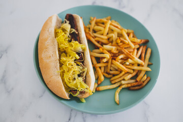 plant-based food, vegan hot dog with sauerkraut and plant-based sausage served with a side of chips