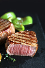grill filet mignon and vegetables, grilled - young potatoes and peppers. steak mignon from the meat of young beef is shown in section, the degree of preparation is 