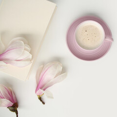 Obraz na płótnie Canvas beautiful tender flat still life, card on a beige background, magnolia buds, a cup of cappuccino, concept of a floral spring background