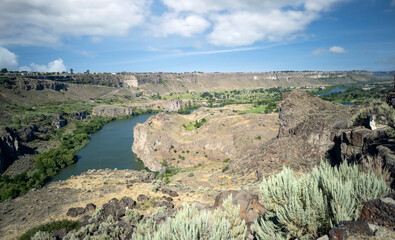 Winding Snake River flowing thru the pacific northwest in the summertime on a partly cloudy day
