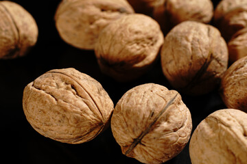Walnuts on a black background. The light was dim.