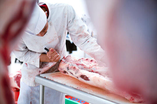 A meat seller cuts fresh meat in a Japanese ham and wagyu beef factory