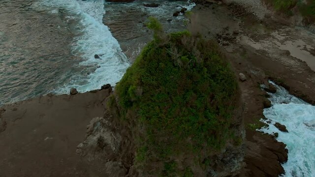 Volcanic rock beach aerial footage in Java Island, Indonesia. Taken from drone flying circle point of view