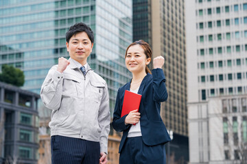 作業服姿のビジネスマンとスーツ姿のビジネスウーマン