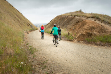 Obraz premium Three people cycling the Otago Central Rail Trail at Poolburn Gorge, South Island